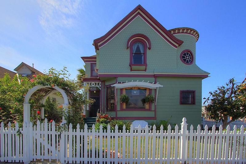 The home features patterned shingling and oriel windows